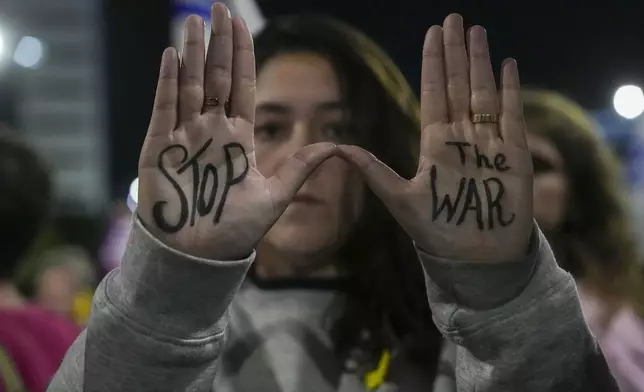 Israelis protest against Prime Minister Benjamin Netanyahu's government and call for the release of hostages held in the Gaza Strip by the Hamas militant group, in Tel Aviv, Israel, Saturday, Dec. 14, 2024. (AP Photo/Tsafrir Abayov)