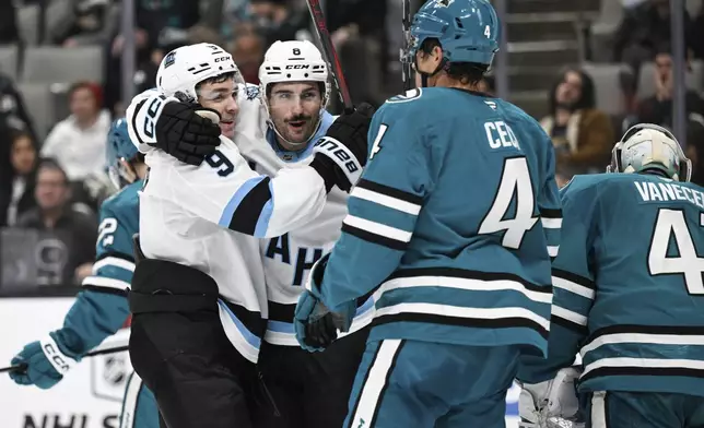 Utah Hockey Club center Nick Schmaltz (8) celebrates his goal with center Clayton Keller (9) against the San Jose Sharks during the second period of an NHL hockey game Saturday, Dec. 14, 2024, in San Jose, Calif. (AP Photo/Eakin Howard)