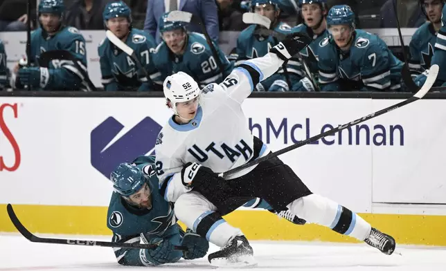 Utah Hockey Club defenseman Vladislav Kolyachonok (52) collides with San Jose Sharks center Luke Kunin (11) during the first period of an NHL hockey game Saturday, Dec. 14, 2024, in San Jose, Calif. (AP Photo/Eakin Howard)