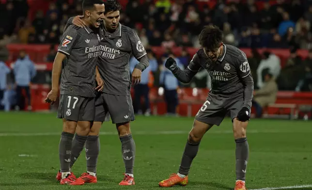 Real Madrid's Arda Guler, right, celebrates with Real Madrid's Lucas Vazquez, left and Brahim Diaz after scoring his side's second goal during a Spanish La Liga soccer match between Girona and Real Madrid at the Montilivi stadium in Girona, Spain, Saturday, Dec. 7, 2024. (AP Photo/Joan Monfort)