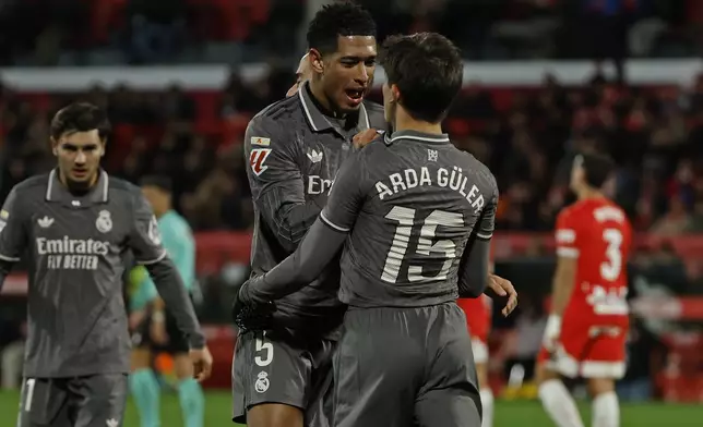 Real Madrid's Arda Guler, centre right, is congratulated by Jude Bellingham after scoring his side's second goal during a Spanish La Liga soccer match between Girona and Real Madrid at the Montilivi stadium in Girona, Spain, Saturday, Dec. 7, 2024. (AP Photo/Joan Monfort)
