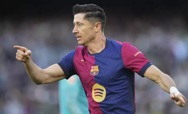 Barcelona's Robert Lewandowski celebrates after scoring his side's opening goal during a Spanish La Liga soccer match between Betis and Barcelona at the Benito Villamarin stadium in Seville, Spain, Saturday, Dec. 7, 2024. (AP Photo/Jose Breton)
