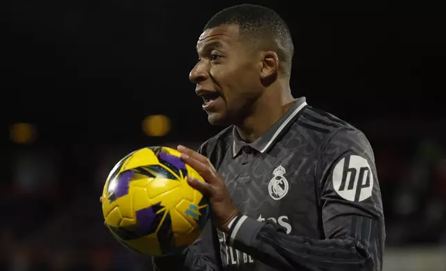Real Madrid's Kylian Mbappe holds the ball during a Spanish La Liga soccer match between Girona and Real Madrid at the Montilivi stadium in Girona, Spain, Saturday, Dec. 7, 2024. (AP Photo/Joan Monfort)
