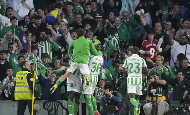 Real Betis players celebrate after Betis' Assane Diao scored his side's second goal during a Spanish La Liga soccer match between Betis and Barcelona at the Benito Villamarin stadium in Seville, Spain, Saturday, Dec. 7, 2024. (AP Photo/Jose Breton)