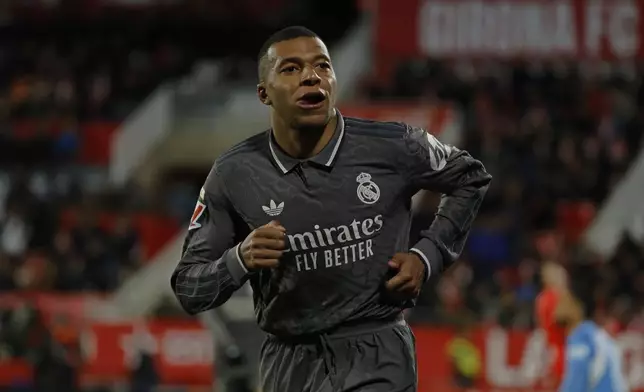 Real Madrid's Kylian Mbappe reacts after scoring his side's third goal during a Spanish La Liga soccer match between Girona and Real Madrid at the Montilivi stadium in Girona, Spain, Saturday, Dec. 7, 2024. (AP Photo/Joan Monfort)