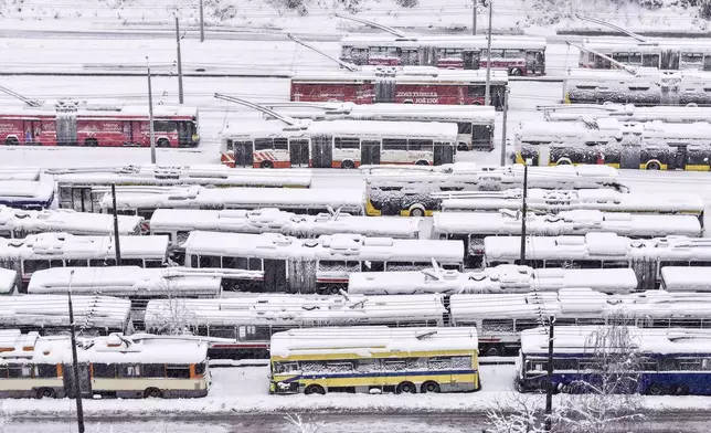 An aerial view of parked trolley buses during heavy snowfall in Sarajevo, Bosnia, Tuesday, Dec. 24, 2024. (AP Photo/Armin Durgut)