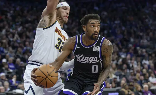 Sacramento Kings guard Malik Monk (0) is guarded by Denver Nuggets forward Aaron Gordon during the second half of an NBA basketball game in Sacramento, Calif., Monday, Dec. 16, 2024. The Nuggets won 130-129. (AP Photo/Randall Benton)