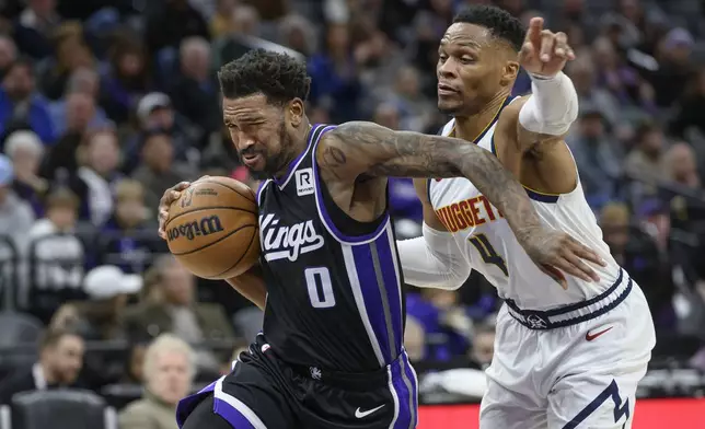 Sacramento Kings guard Malik Monk (0) drives past Denver Nuggets guard Russell Westbrook (4) during the second half of an NBA basketball game in Sacramento, Calif., Monday, Dec. 16, 2024. The Nuggets won 130-129. (AP Photo/Randall Benton)