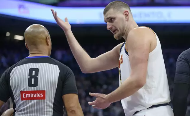Denver Nuggets center Nikola Jokic, right, discusses an official's call with referee Marc Davis (8) during the first half of an NBA basketball game against the Sacramento Kings in Sacramento, Calif., Monday, Dec. 16, 2024. (AP Photo/Randall Benton)