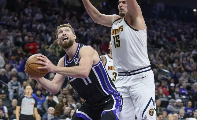 Sacramento Kings forward Domantas Sabonis (11) is guarded by Denver Nuggets center Nikola Jokic (15) during the second half of an NBA basketball game in Sacramento, Calif., Monday, Dec. 16, 2024. The Nuggets won 130-129. (AP Photo/Randall Benton)