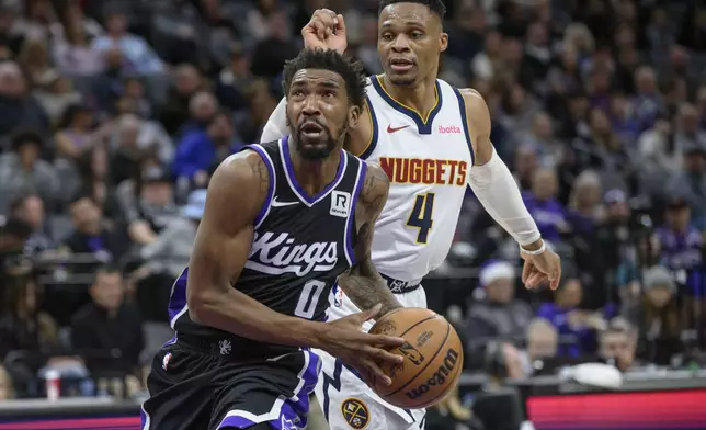 Sacramento Kings guard Malik Monk (0) drives past Denver Nuggets guard Russell Westbrook (4) during the second half of an NBA basketball game in Sacramento, Calif., Monday, Dec. 16, 2024. The Nuggets won 130-129. (AP Photo/Randall Benton)