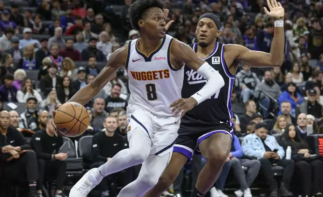 Denver Nuggets forward Peyton Watson (8) drives past Sacramento Kings Orlando Robinson, right, during the first half of an NBA basketball game in Sacramento, Calif., Monday, Dec. 16, 2024. (AP Photo/Randall Benton)