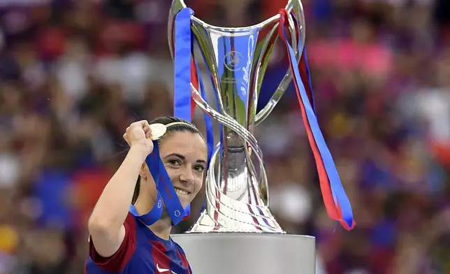 FILE - Barcelona's Aitana Bonmati holding up her medal walks past the trophy after winning the women's Champions League final soccer match between FC Barcelona and Olympique Lyonnais at the San Mames stadium in Bilbao, Spain, Saturday, May 25, 2024. (AP Photo/Alvaro Barrientos, FIle)