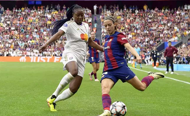 FILE - Barcelona's Aitana Bonmati crosses the ball past Lyon's Kadidiatou Diani, left, during the women's Champions League final soccer match between FC Barcelona and Olympique Lyonnais at the San Mames stadium in Bilbao, Spain, Saturday, May 25, 2024. (AP Photo/Alvaro Barrientos, File)