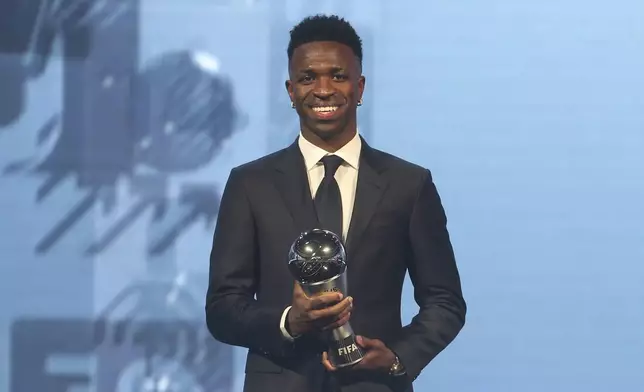 Vinicius Junior of Real Madrid is awarded as the Best Men's FIFA Player during the FIFA Football Awards 2024 in Doha, Qatar, Tuesday, Dec. 17, 2024. (AP Photo/Hussein Sayed)