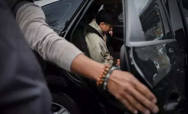 A deportation officer with Enforcement and Removal Operations in U.S. Immigration and Customs Enforcement's New York City field office puts Wilmer Patricio Medina-Medina in the back of a car after arresting him during an early morning operation, Tuesday, Dec. 17, 2024, in the Bronx borough of New York. (AP Photo/Julia Demaree Nikhinson)