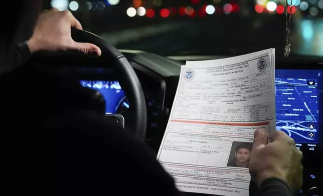 Kenneth Genalo, director of U.S. Immigration and Customs Enforcement's New York City field office, holds an information sheet on Wilmer Patricio Medina-Medina during an early morning operation, Tuesday, Dec. 17, 2024, in the Bronx borough of New York. (AP Photo/Julia Demaree Nikhinson)