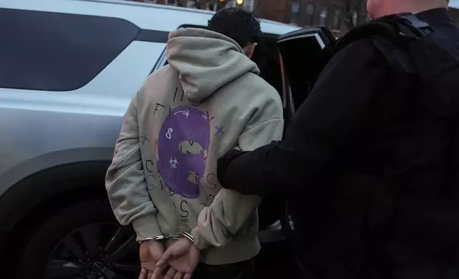 Deportation officers with Enforcement and Removal Operations in U.S. Immigration and Customs Enforcement's New York City field office arrest Wilmer Patricio Medina-Medina during an early morning operation, Tuesday, Dec. 17, 2024, in the Bronx borough of New York. (AP Photo/Julia Demaree Nikhinson)