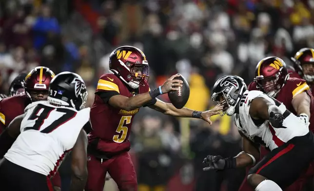 Washington Commanders quarterback Jayden Daniels (5) scrambles between Atlanta Falcons defensive end Grady Jarrett (97) and defensive tackle David Onyemata during the second half of an NFL football game, Sunday, Dec. 29, 2024, in Landover, Md. (AP Photo/Nick Wass)