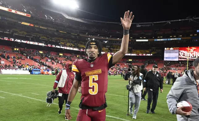 Washington Commanders quarterback Jayden Daniels (5) waves to the crowd after an overtime victory over the Atlanta Falcons during an NFL football game, Sunday, Dec. 29, 2024, in Landover, Md. The Commanders won 30-24. (AP Photo/Nick Wass)