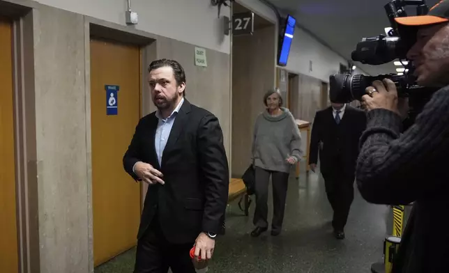 Timothy Oliver Lee, left, brother of Cash App founder Bob Lee, walks to Department 28 to enter the courtroom at the Hall of Justice for the murder trial of Nima Momeni, Tuesday, Dec. 3, 2024, in San Francisco. (AP Photo/Godofredo A. Vásquez)