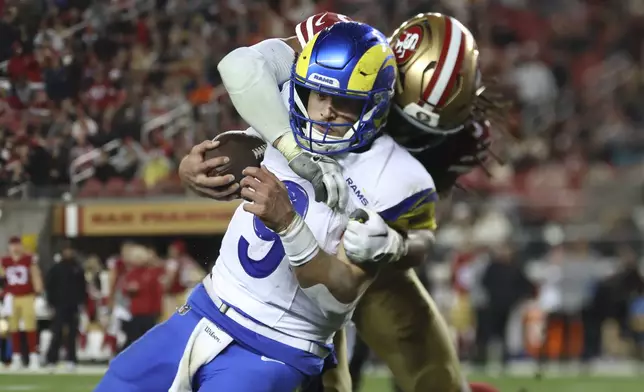Los Angeles Rams quarterback Matthew Stafford, left, runs against San Francisco 49ers linebacker Fred Warner during the second half of an NFL football game in Santa Clara, Calif., Thursday, Dec. 12, 2024. (AP Photo/Jed Jacobsohn)