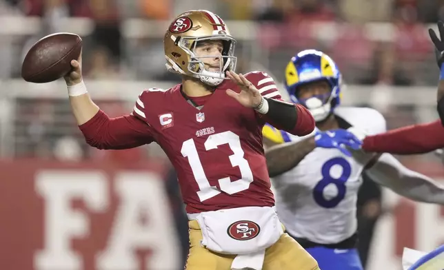 San Francisco 49ers quarterback Brock Purdy (13) passes as Los Angeles Rams linebacker Jared Verse (8) applies pressure during the second half of an NFL football game in Santa Clara, Calif., Thursday, Dec. 12, 2024. (AP Photo/Godofredo A. Vásquez)