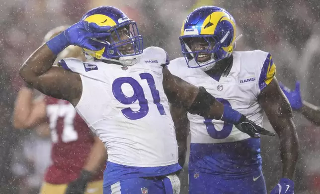Los Angeles Rams defensive tackle Kobie Turner (91) celebrates with linebacker Byron Young (0) after sacking San Francisco 49ers quarterback Brock Purdy during the first half of an NFL football game in Santa Clara, Calif., Thursday, Dec. 12, 2024. (AP Photo/Godofredo A. Vásquez)