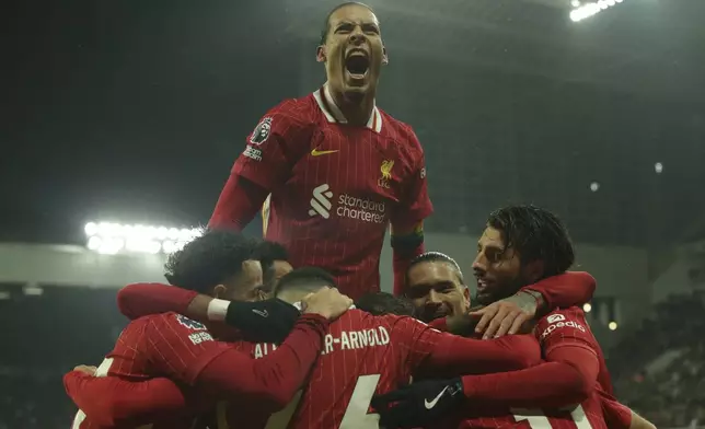 Liverpool's Mohamed Salah celebrates with teammates after scoring his side's third goal during the English Premier League soccer match between Newcastle and Liverpool, at St. James Park in Newcastle, England, Wednesday, Dec 4, 2024. (AP Photo/Ian Hodgson)