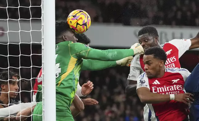 Manchester United's goalkeeper Andre Onana, center, saves a ball during the English Premier League soccer match between Arsenal and Manchester United at Emirates stadium in London, Wednesday, Dec. 4, 2024. (AP Photo/Kirsty Wigglesworth)