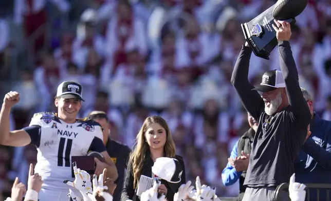 Navy head coach Brian Newberry, right, holds the Lockheed Martin Armed Forces Bowl trophy following the Armed Forces Bowl NCAA college football game against Oklahoma, Friday, Dec. 27, 2024, in Fort Worth, Texas. Navy won 21-20. (AP Photo/Julio Cortez)