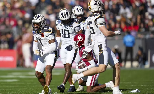 Navy cornerback Dashaun Peele (1) reacts after making a tackle against Oklahoma wide receiver Zion Ragins, bottom right, during the first half of the Armed Forces Bowl NCAA college football game, Friday, Dec. 27, 2024, in Fort Worth, Texas. (AP Photo/Julio Cortez)