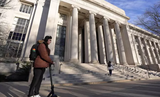 A person rides a scooter, Tuesday, Dec. 17, 2024, near an entrance to Massachusetts Institute of Technology in Cambridge, Mass. (AP Photo/Steven Senne)