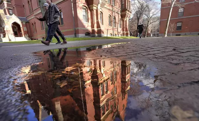 People walk between buildings, Tuesday, Dec. 17, 2024, on the campus of Harvard University in Cambridge, Mass. (AP Photo/Steven Senne)