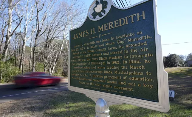 A car speeds past a Mississippi Department of Archives and History marker recognizing the birthplace and legacy of James Meredith in the Civil Rights Movement, in Kosciusko, Miss., Friday, Dec. 20, 2024. Meredith, was the first Black student to enroll at the University of Mississippi in 1962. (AP Photo/Rogelio V. Solis)