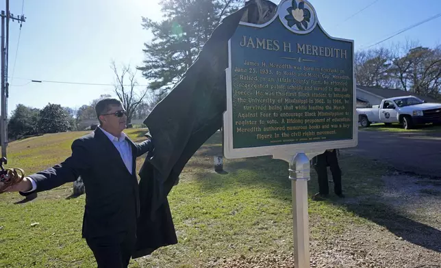 Kosciusko, Miss., Mayor Tim Kyle, unveils a Mississippi Department of Archives and History marker recognizing the birthplace and civil rights movement legacy of James Meredith, who became the first Black student to enroll at the University of Mississippi in 1962, Friday, Dec. 20, 2024, in Kosciusko, Miss. (AP Photo/Rogelio V. Solis)