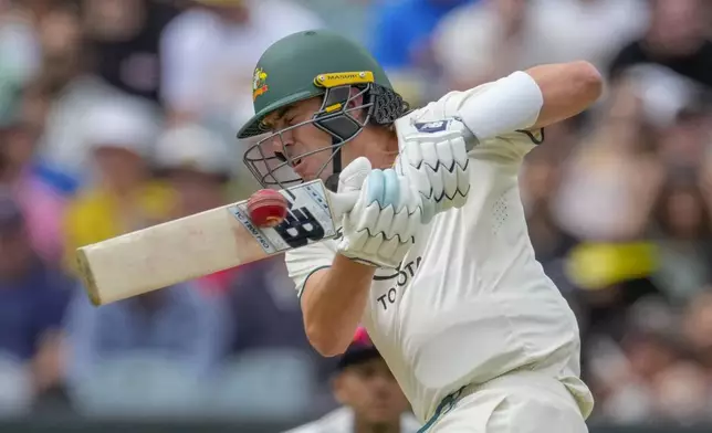 Australia's captain Pat Cummins plays a shot during play on the second day of the fourth cricket test between Australia and India at the Melbourne Cricket Ground, Melbourne, Australia, Friday, Dec. 27, 2024. (AP Photo/Asanka Brendon Ratnayake)