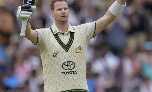 Australia's Steve Smith raises his bat as he celebrates after scoring his century during play on the second day of the fourth cricket test between Australia and India at the Melbourne Cricket Ground, Melbourne, Australia, Friday, Dec. 27, 2024. (AP Photo/Asanka Brendon Ratnayake)