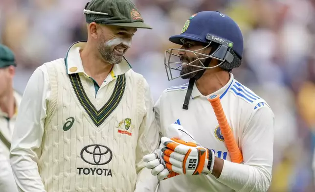 India's Ravindra Jadeja, right, talks to Australia's Nathan Lyon as they walk off the field on the end of play of the second day of the fourth cricket test between Australia and India at the Melbourne Cricket Ground, Melbourne, Australia, Friday, Dec. 27, 2024. (AP Photo/Asanka Brendon Ratnayake)