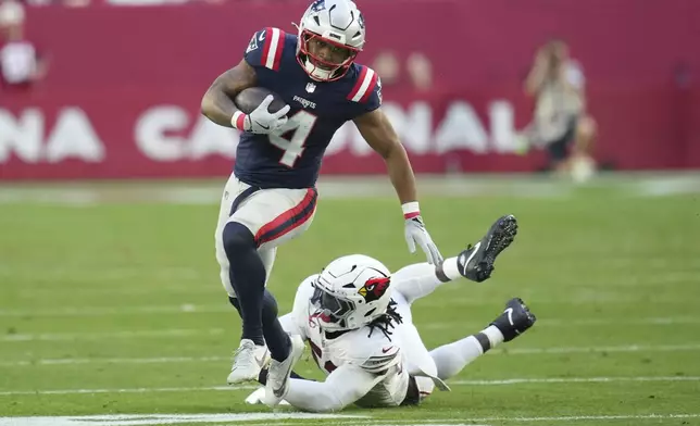 New England Patriots running back Antonio Gibson (4) eludes the reach of Arizona Cardinals linebacker Victor Dimukeje during the second half of an NFL football game, Sunday, Dec. 15, 2024, in Glendale, Ariz. (AP Photo/Ross D. Franklin)