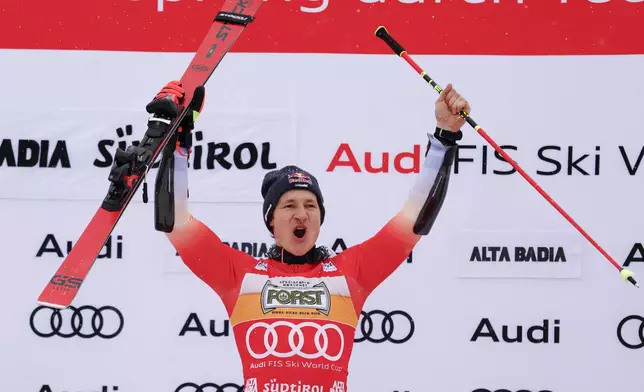 Switzerland's Marco Odermatt celebrates on the podium after winning an alpine ski, men's World Cup giant slalom, in Alta Badia, Italy, Sunday, Dec. 22, 2024. (AP Photo/Alessandro Trovati)