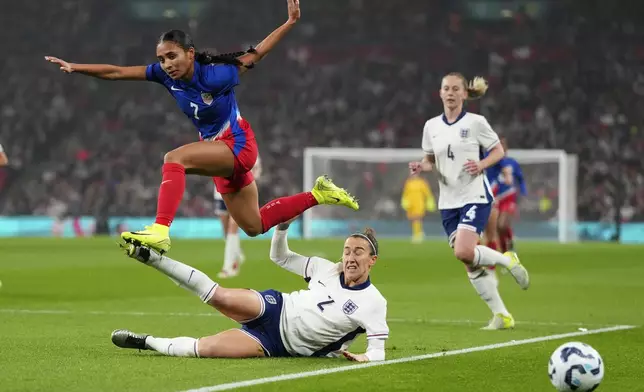 United States' Alyssa Thompson jumps over England's Lucy Bronze during the International friendly women soccer match between England and United States at Wembley stadium in London, Saturday, Nov. 30, 2024. (AP Photo/Kirsty Wigglesworth)