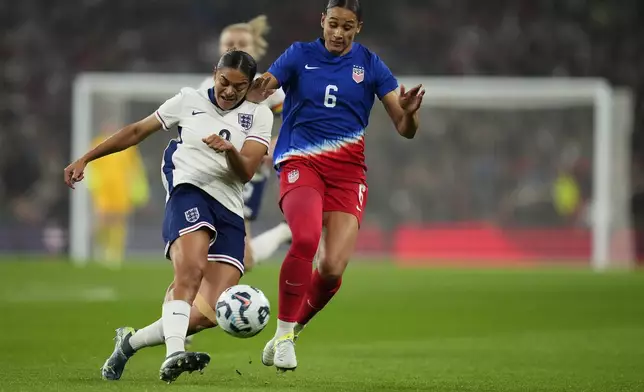 England's Jessica Carter, left, and United States' Lynn Williams challenge for the ball during the International friendly women soccer match between England and United States at Wembley stadium in London, Saturday, Nov. 30, 2024. (AP Photo/Kirsty Wigglesworth)