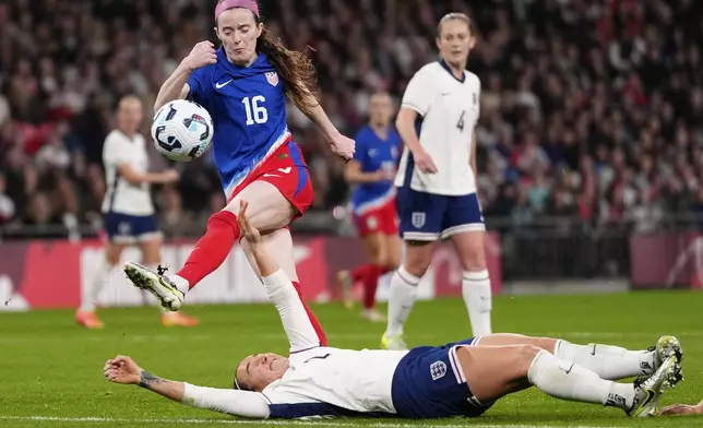 United States' Rose Lavelle, left, and England's Lucy Bronze challenge for the ball during the International friendly women soccer match between England and United States at Wembley stadium in London, Saturday, Nov. 30, 2024. (AP Photo/Kirsty Wigglesworth)