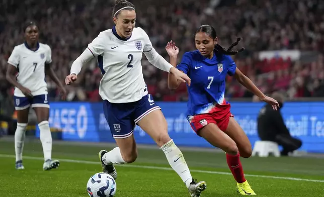 England's Lucy Bronze and United States' Alyssa Thompson, right, challenge for the ball during the International friendly women soccer match between England and United States at Wembley stadium in London, Saturday, Nov. 30, 2024. (AP Photo/Kirsty Wigglesworth)