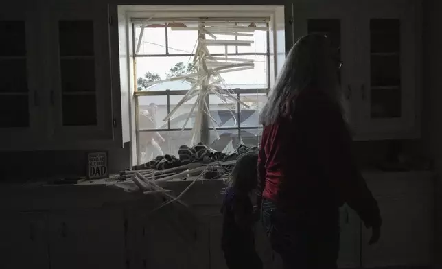 Alyssa Duncin, 26, walks with her daughter Kingsley Duncin, 3, through the family home just after it was destroyed by a tornado that hit nearby on Saturday, Dec. 28, 2024, in Alvin, Texas. (Raquel Natalicchio/Houston Chronicle via AP)