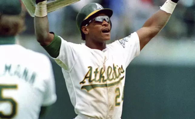 FILE - Oakland Athletics' Rickey Henderson holds up third base after breaking Lou Brock's all-time career record for stolen bases during the fourth inning of a baseball game against the New York Yankees in Oakland, Calif., May 1, 1991. (AP Photo/Alan Greth, File)