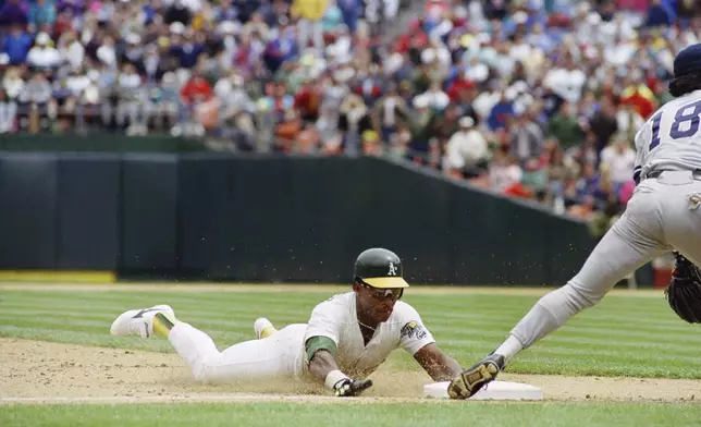 FILE - Oakland Athletics' Rickey Henderson, left, goes sliding into third base to steal his 939th career base to set a new all-time major league record during their game with the New York Yankees at Oakland, May 1, 1991. (AP Photo/Eric Risberg, File)