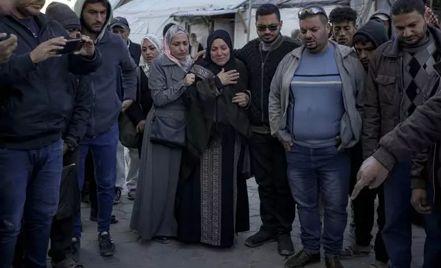 Palestinians react next to the bodies of their relatives who were killed in the Israeli bombardment of the Gaza Strip at Al-Aqsa Hospital in Deir Al-Balah, Wednesday, Dec. 25, 2024. (AP Photo/Abdel Kareem Hana)