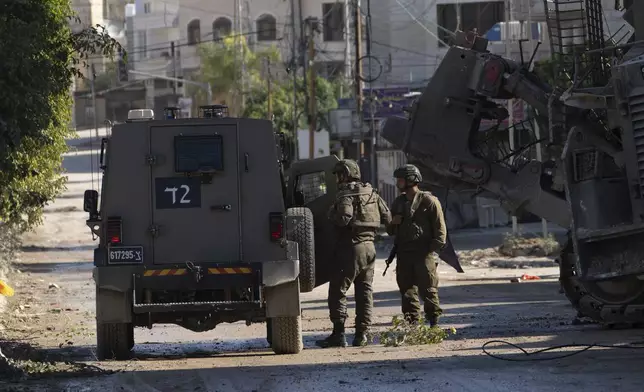 Members of Israeli forces patrol a street during a military operation in the Tulkarem refugee camp near the West Bank city of Tulkarem, Wednesday, Dec. 25, 2024. (AP Photo/Majdi Mohammed)